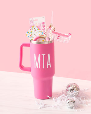 A pink 40 ounce tumbler is monogrammed and filled with a gift card and some jewelry