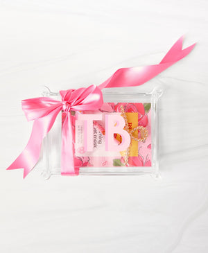 An acrylic box is customized with pink monogram and gifted with a pink bow.