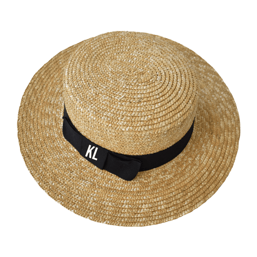 Close-up of a Monogrammed Boater Hat featuring a wide, woven straw brim and a sleek black grosgrain ribbon embroidered with white "KL" initials—perfect for personalized sun protection with a timeless, coastal-chic look.