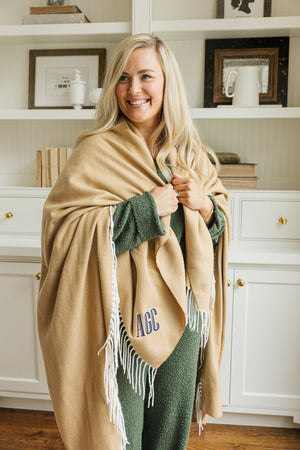 Camel Monogrammed Woven Blanket with embroidered initials AGC, wrapped around shoulders.