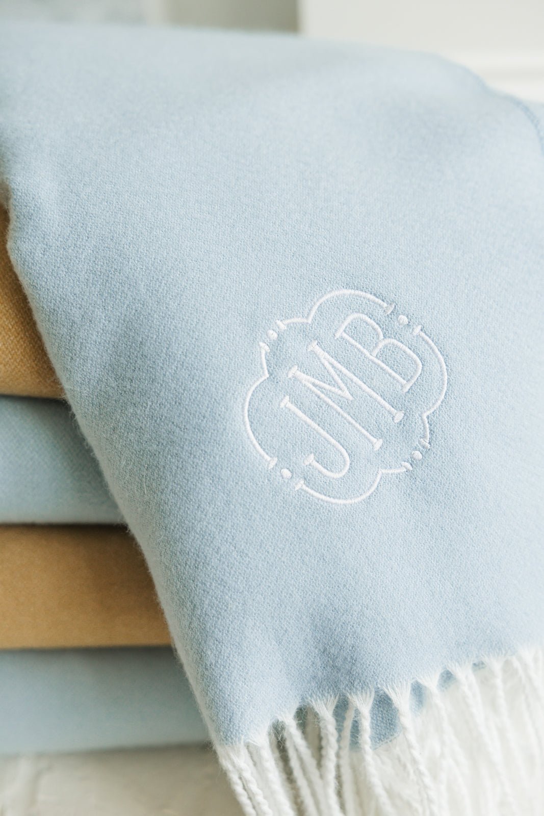 Blue and camel Monogrammed Woven Blankets with white fringe and personalized embroidery initials.