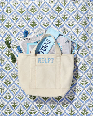 Canvas needlepoint project tote with floral lining, embroidered craft bag.