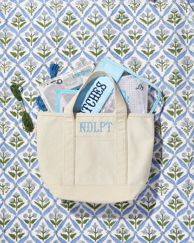 Canvas needlepoint project tote with floral lining, embroidered craft bag.