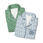 Folded green floral pajama set with white trim and folded blue floral pajama set with navy trim.