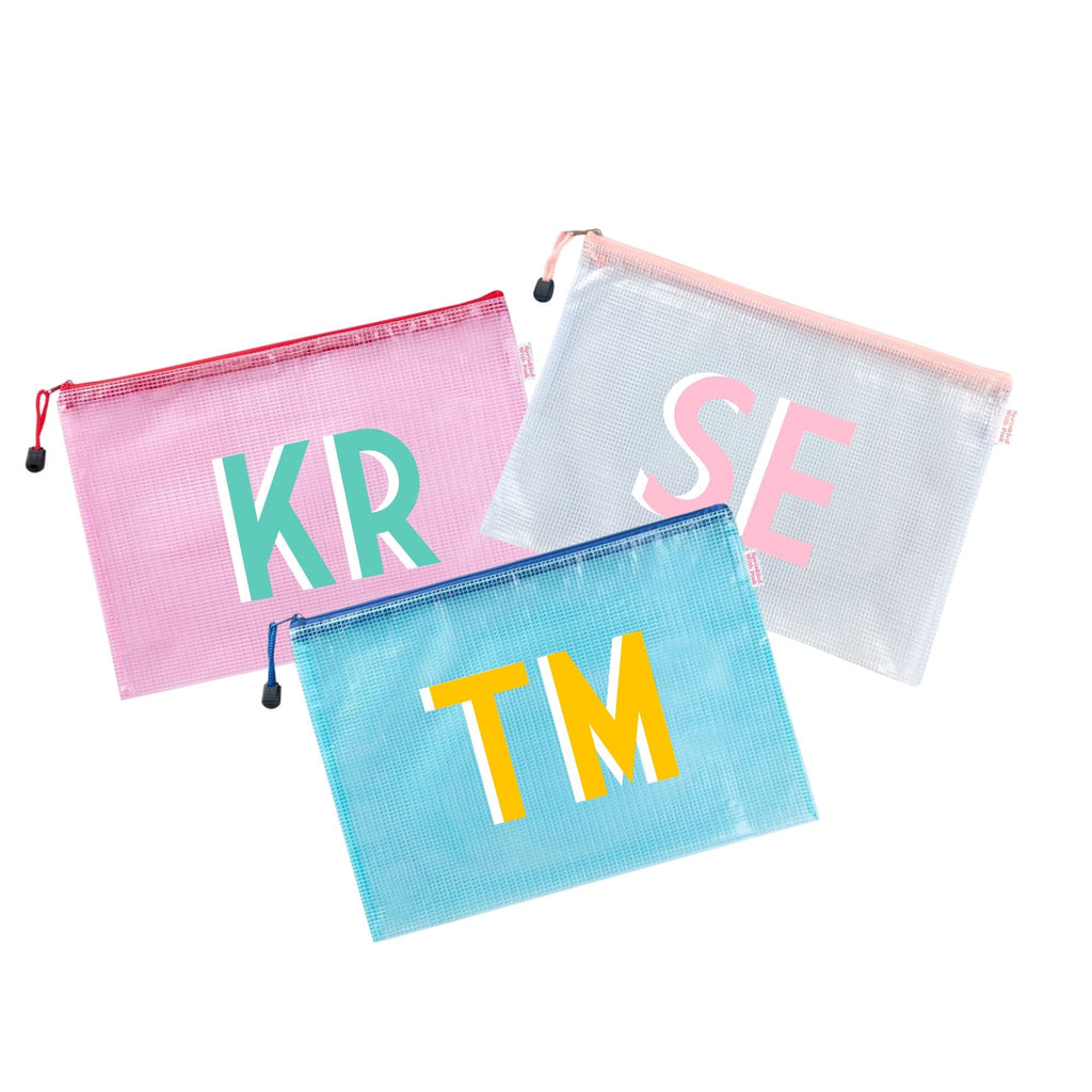 A group of pink, blue and white pool bags are customized with colorful monograms.