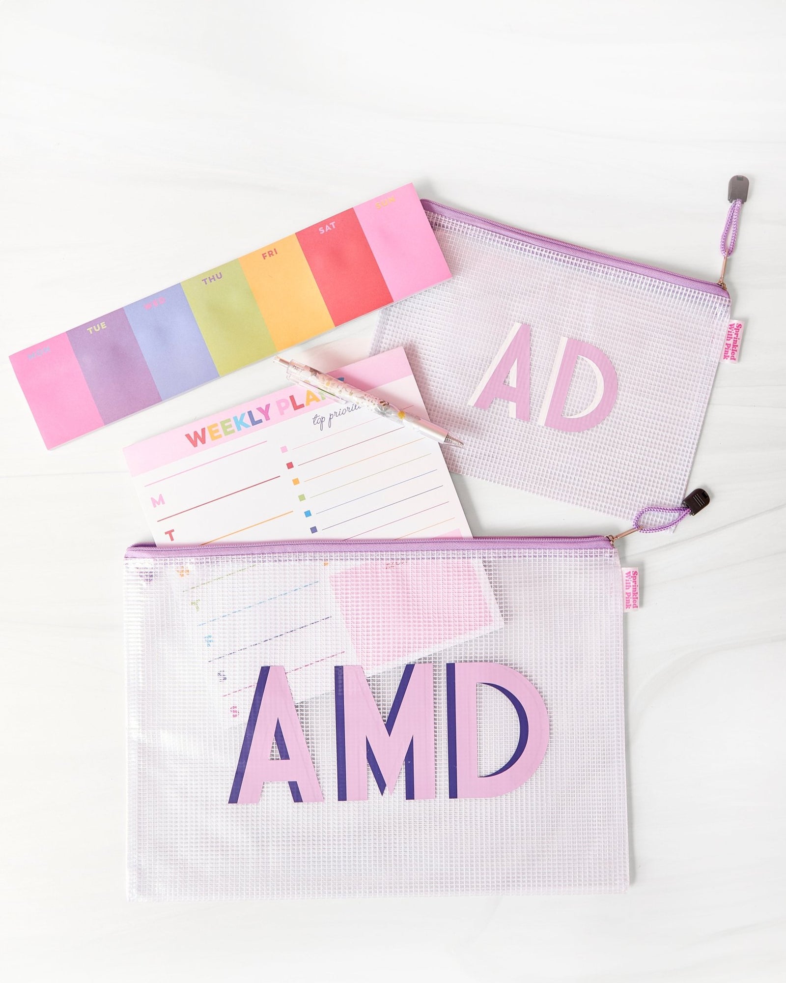 A group of pink, blue and white pool bags are customized with colorful monograms.