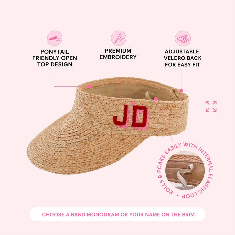 Straw visor embroidered 'JD' in pink and red on the band, with icons describing its ponytail-friendly open top, premium embroidery, and adjustable velcro back.