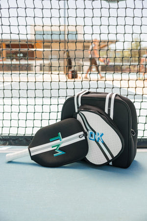 A black and silver pickleball bag and paddle cover are customized with fun monograms