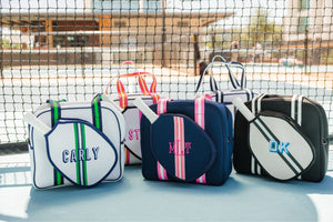 A group of pickleball bags are customized with colorful embroidered monograms and names