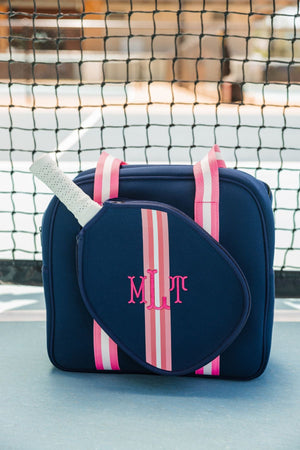 A navy and pink pickleball bag is customized with a pink monogram on a pickleball court