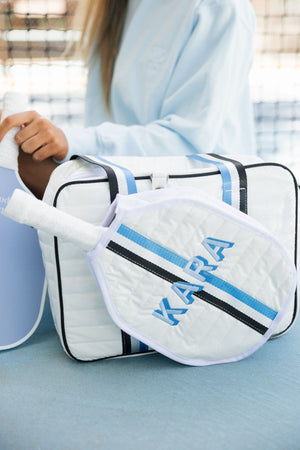 A blue and black striped puffer pickleball bag is customized with a embroidered name in blue thread.
