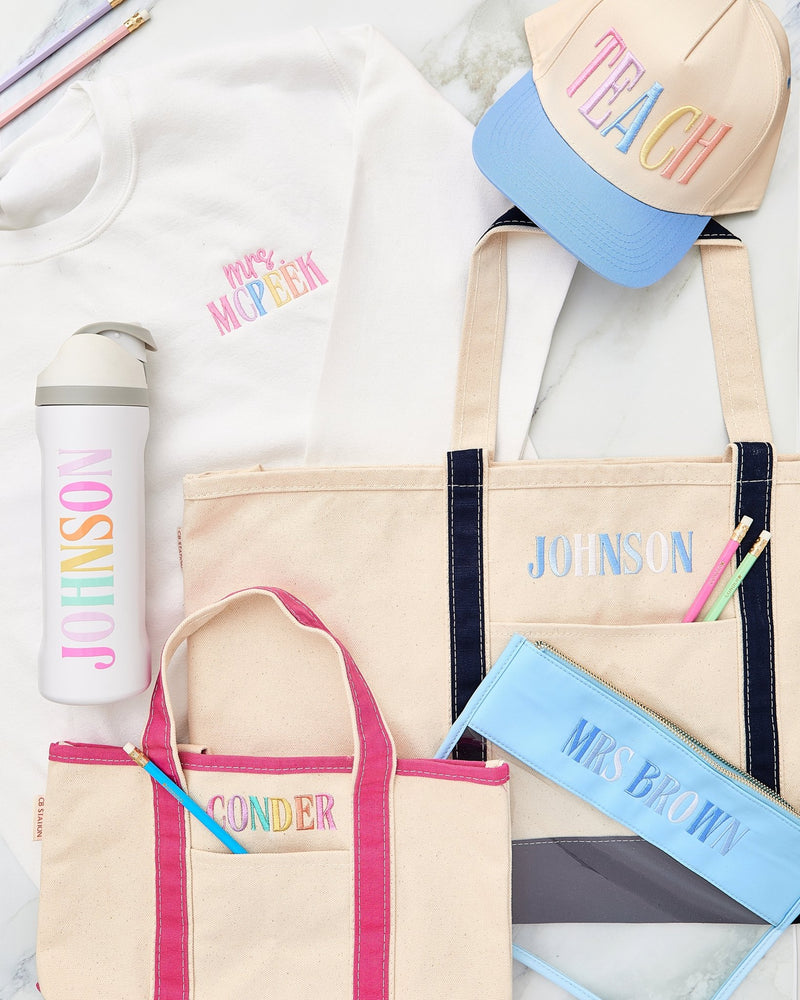 Styled teacher essentials flat lay – @PBANDJ4THGRADE x SWP Embroidered Teacher Canvas Tote in natural canvas with navy-blue trim and “JOHNSON” monogram