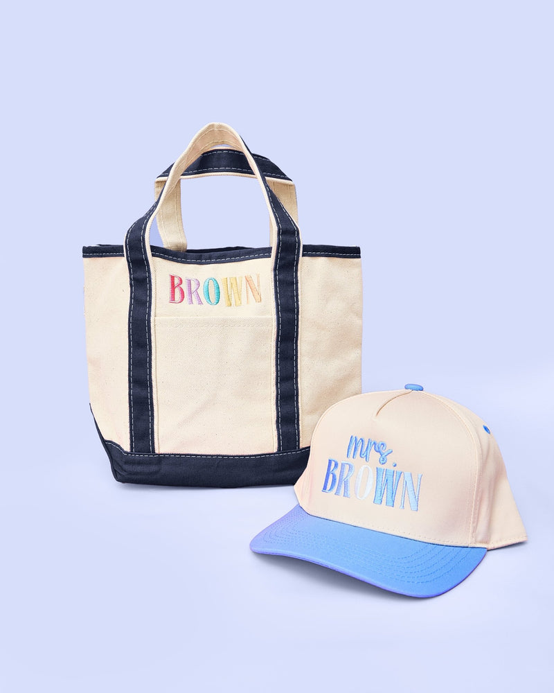 Teacher Tote & Hat Bundle – @PBANDJ4THGRADE x SWP: natural canvas tote with navy-blue trim personalized “Brown” and matching trucker hat with sky-blue brim “Mrs. Brown” embroidery