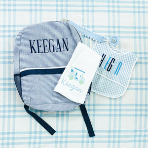 Personalized baby set for Keegan, including a striped backpack, bib, towel, and pacifier clip