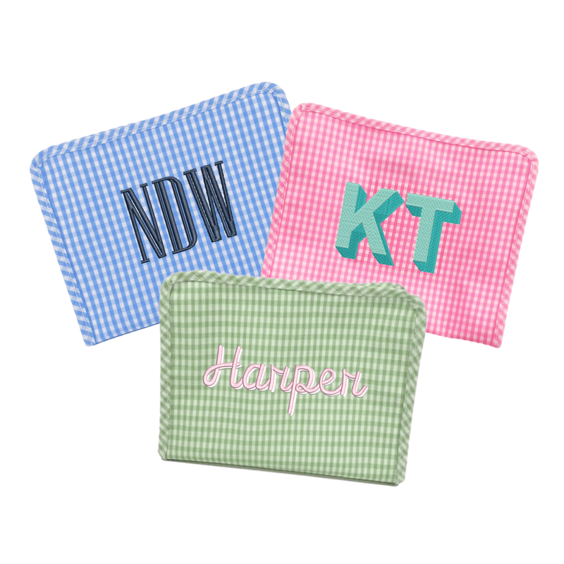 Personalized gingham TRVL Roadie bags in blue, pink, and green with monogram and name embroidery