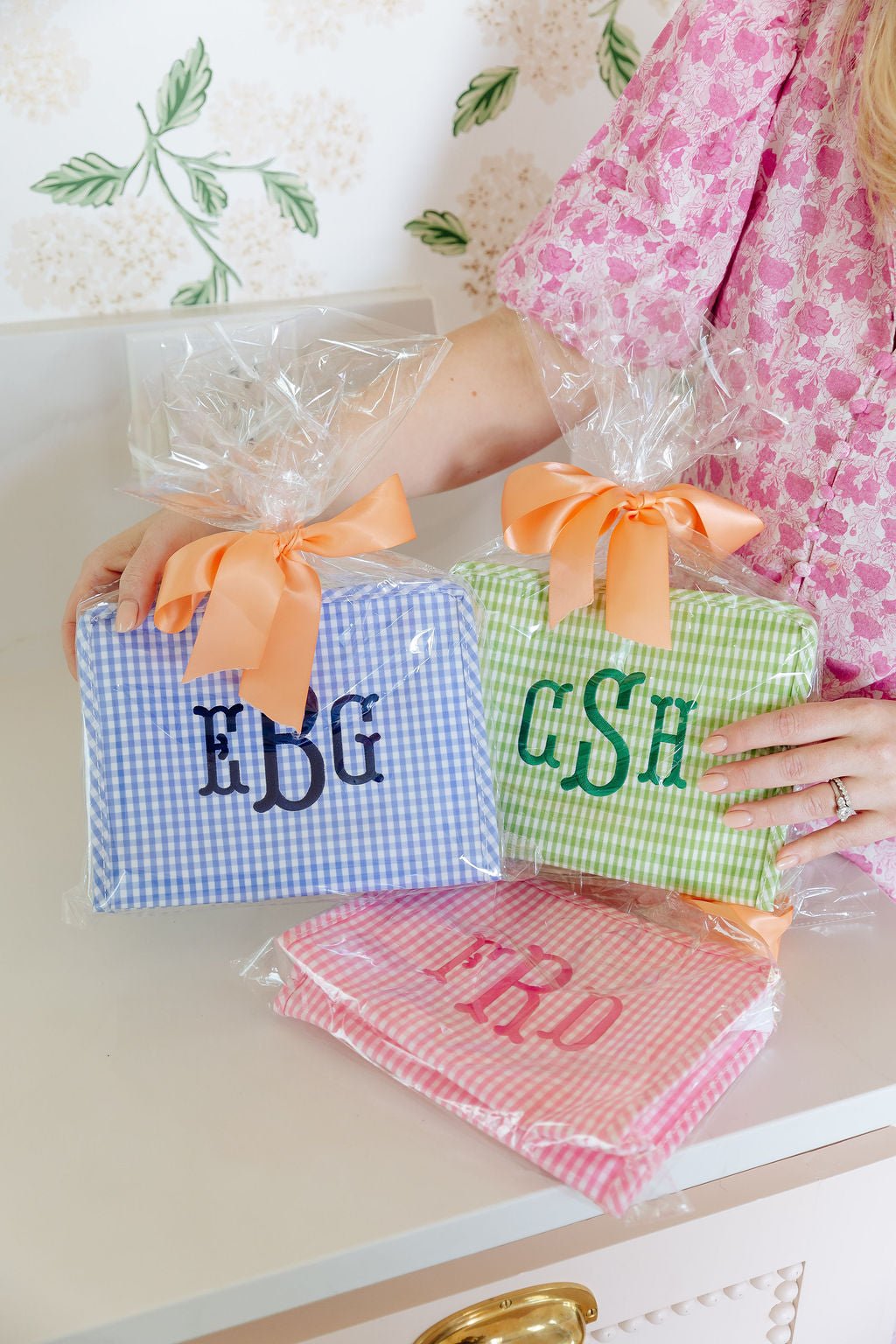 Personalized gingham TRVL Roadie bags in blue, pink, and green with monogram and name embroidery