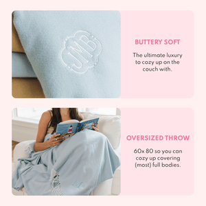Close-up of a light blue woven blanket monogrammed 'JMB' and a woman reading a book wrapped in the oversized blanket on a chair, with text describing it as buttery soft and an oversized 60 by 80 inch throw.