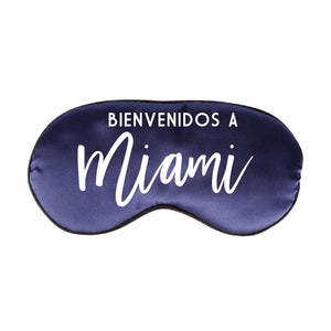 A navy colored sleep mask reads "bienvenidos a Miami"