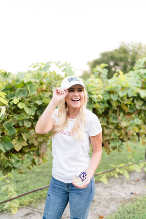 A bride in a vineyard sports customized products including a "Bride" baseball cap