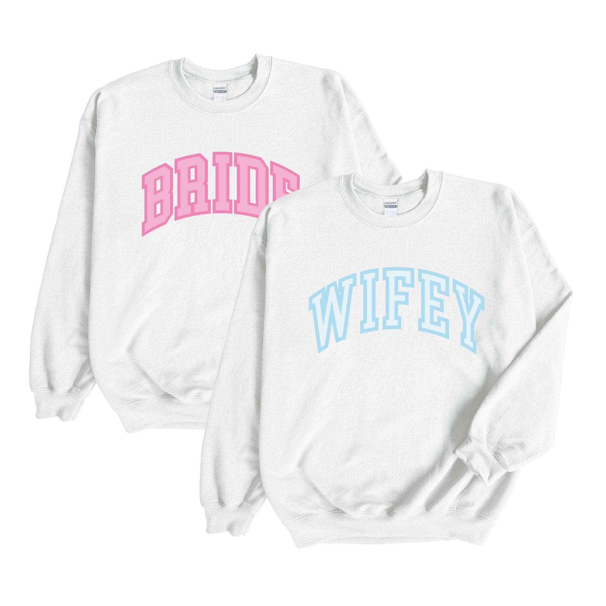 A white sweatshirt with "Bride" written on the front in pink and a white sweatshirt with "Wifey" written on the front in blue