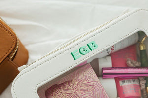 A white leather case is personalized with a mint and green monogram.