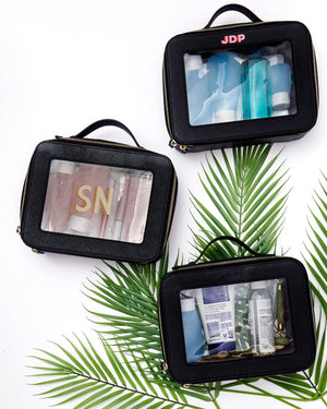 A group of black clear leather toiletry pouches are monogrammed.