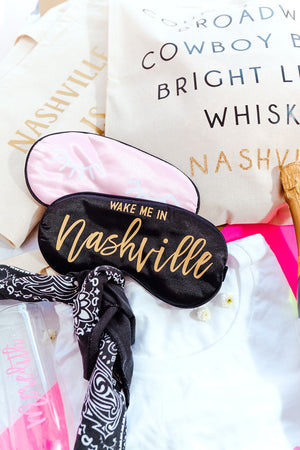 A black sleep mask lays among other products that would be great for a trip to Nashville