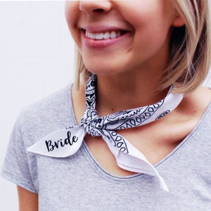 A bride shows off her custom white bandana which reads "Bride" in a black font.