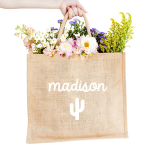 A custom jute bag reads "Madison" on the front in cursive with a cactus icon