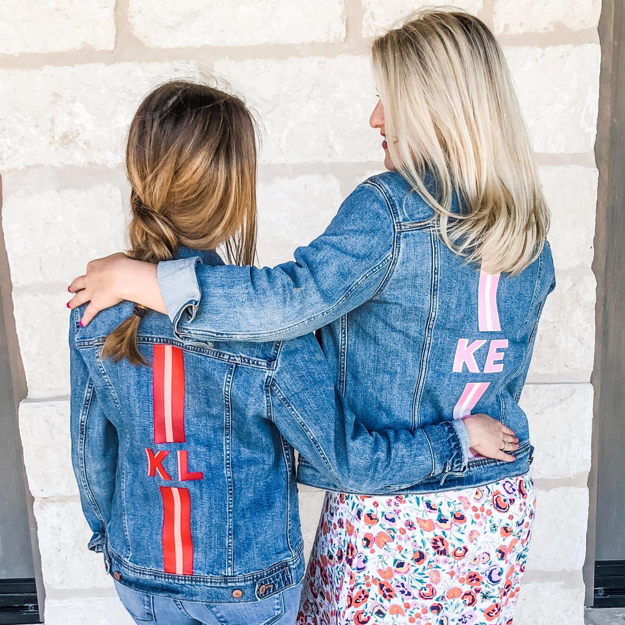 Two women wear customized denim jackets with stripes