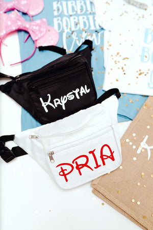 A black and white fanny pack are customized with white and red names on the front pocket.