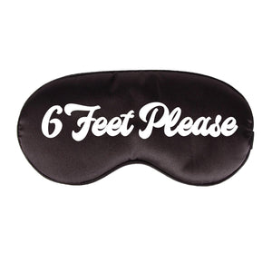 A black sleep mask customized with "6 Feet Please" in white font.