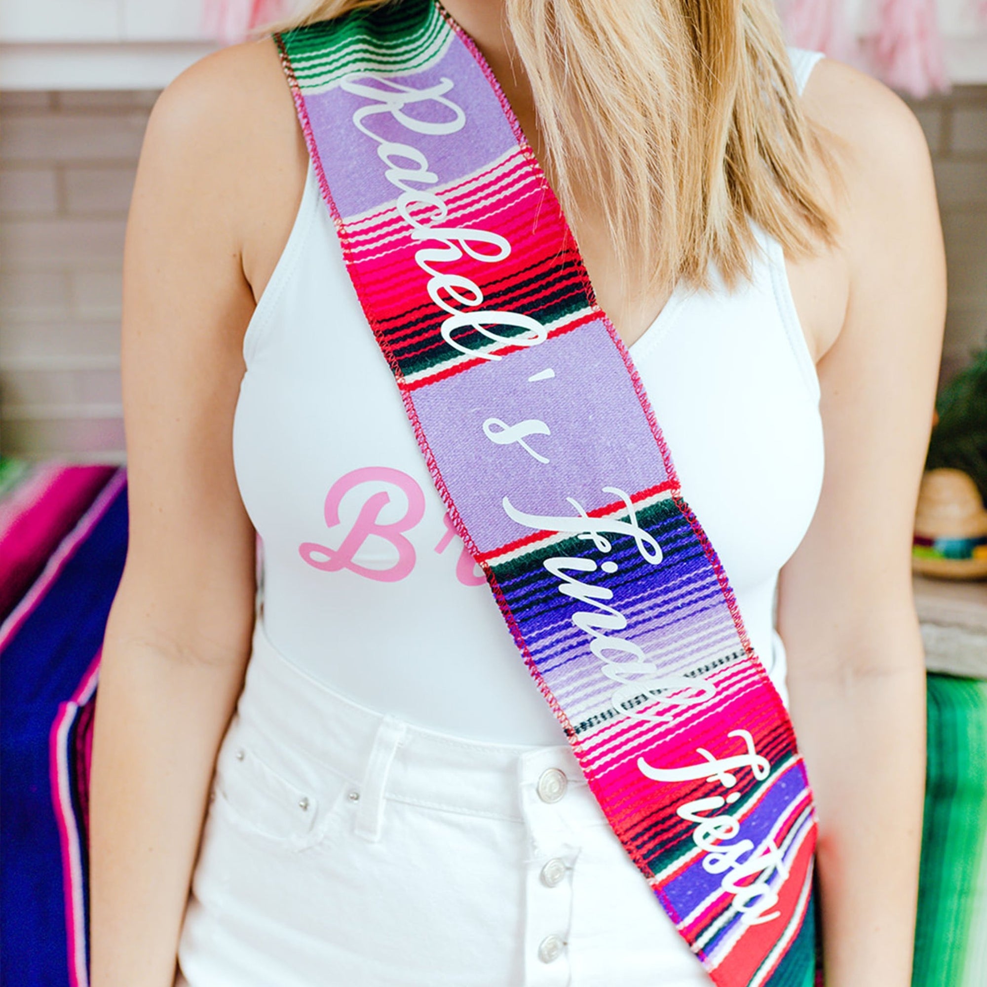 A bride-to-be wears a personalized Final Fiesta serape sash