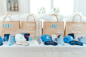 Goodie bags filled with white and blue customized products sit on a table