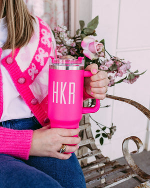 A woman in a pink sweater holds a matching hot pink tumbler