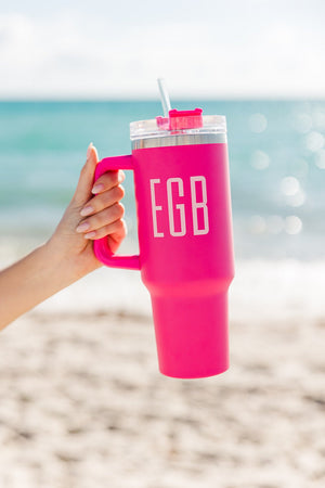 A hot pink tumbler with "EGB" monogrammed on the front