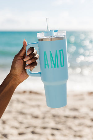 A light blue tumbler with "AMD" monogrammed on the front
