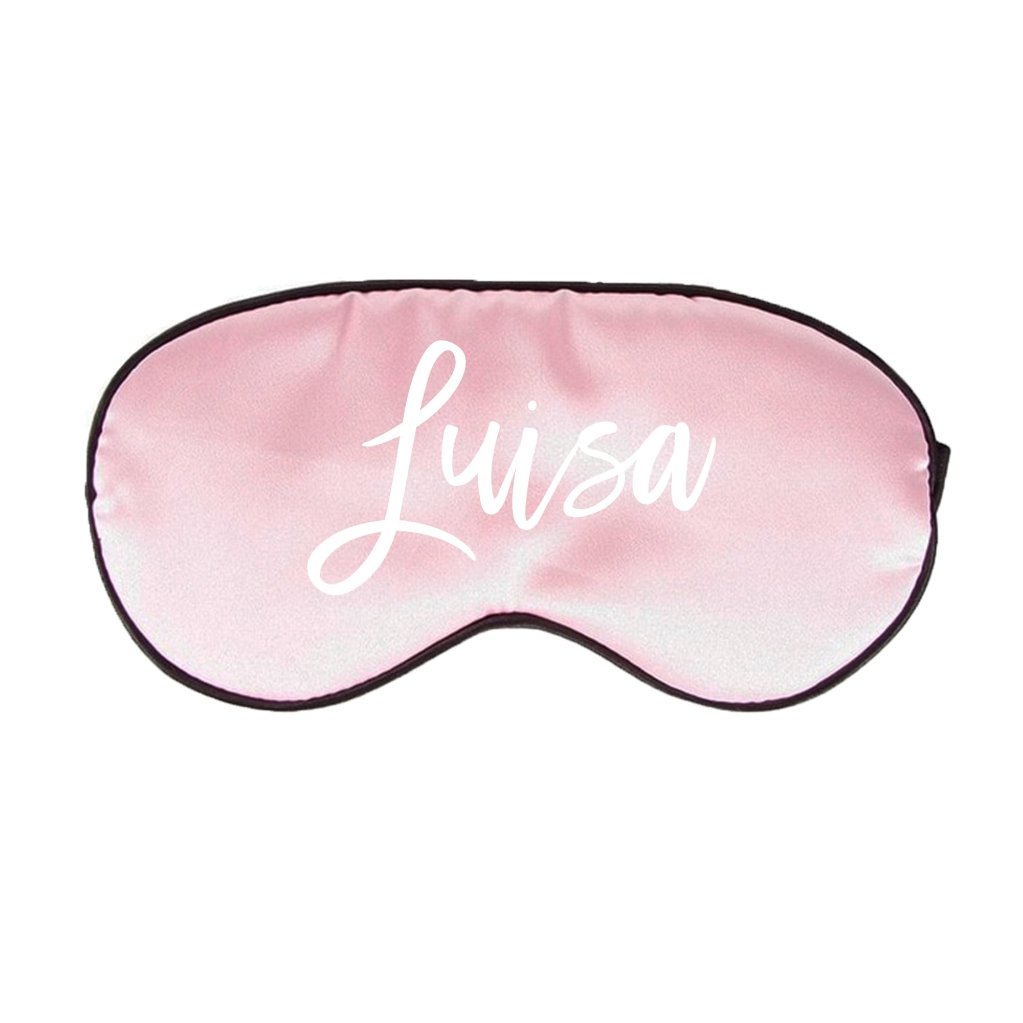 A pink sleep mask is customized with a white script name.