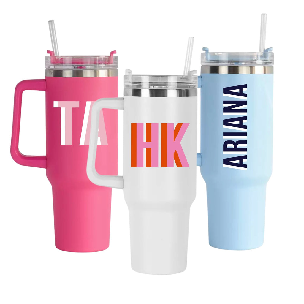 Three custom tumblers with handles in pink, white, and blue