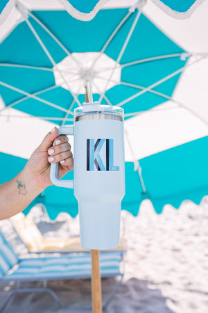 A blue monogrammed tumbler that reads "KL"