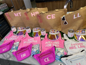 Customized bachelorette party goody bags are laid out on a table