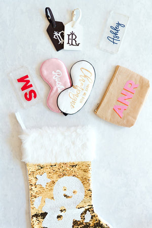 An assortment of products is shown near a glittery stocking to show the perfect customized stocking stuffers.