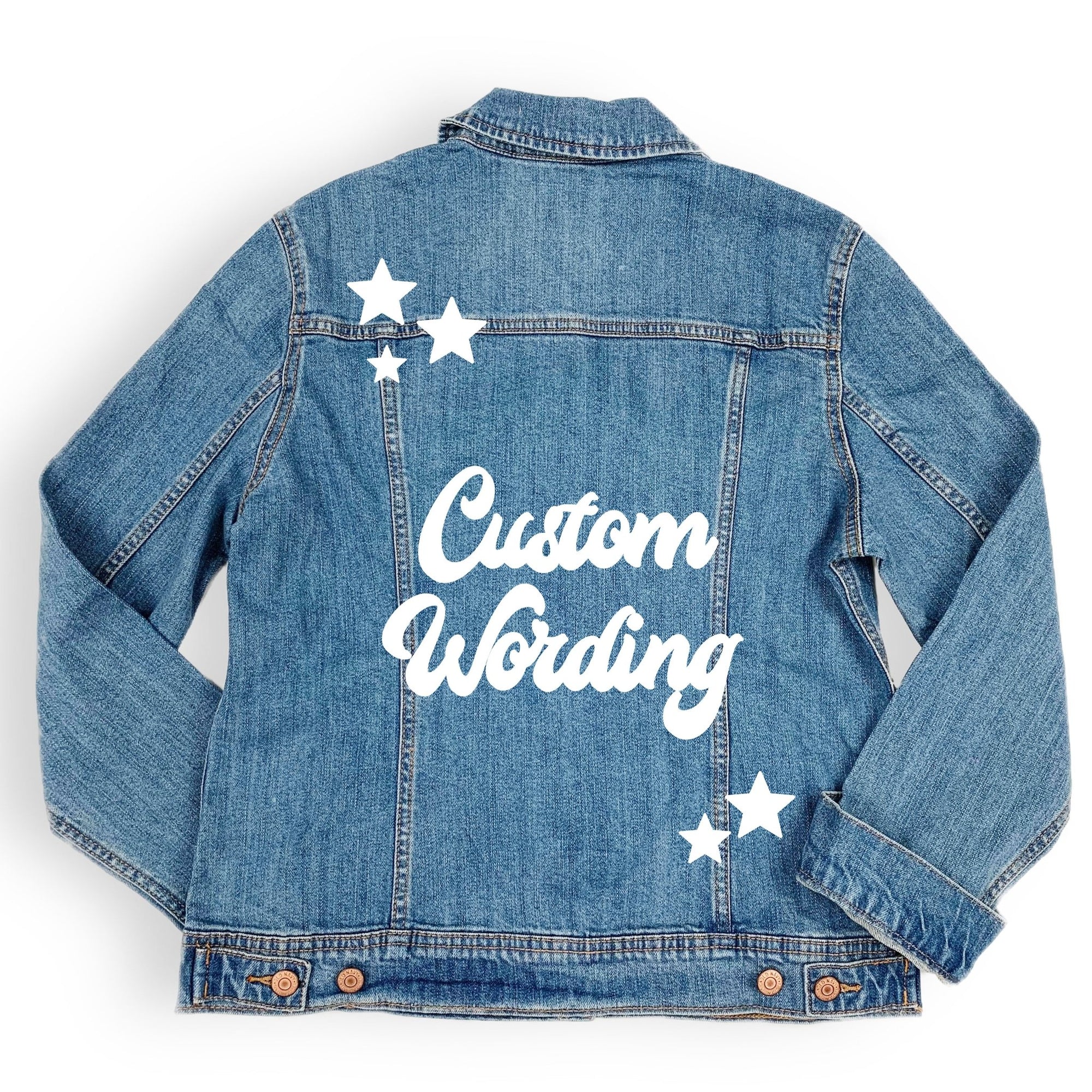 A jean jacket lays showing the customized wording and stars on the back.