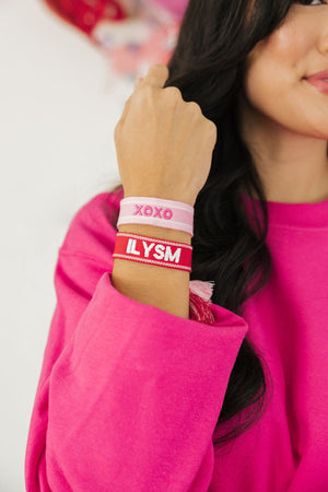 A girl wears a pink and red bracelet customized for Valentine's Day