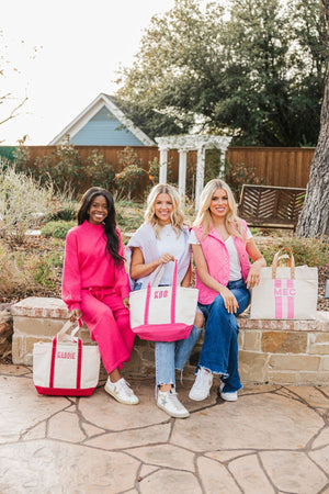 Three girls sit with their personalized tote bags