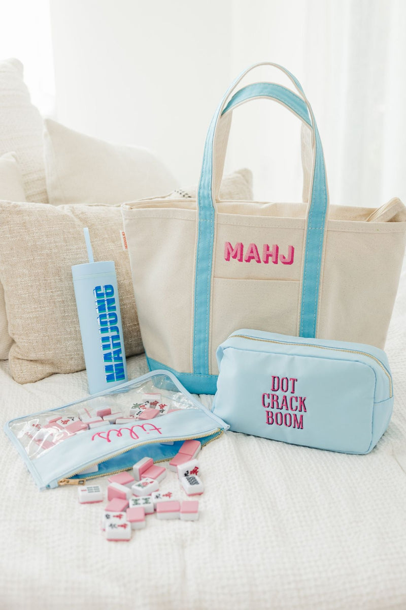 An array of custom Mahjong products sits on a bed