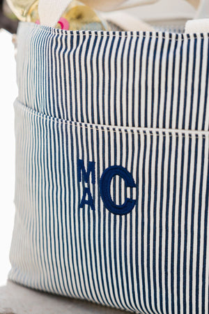 A navy monogram is embroidered into a navy cooler bag.