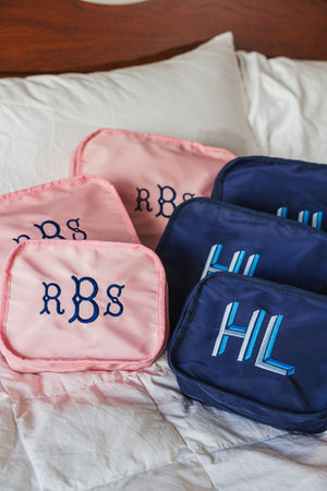 A group of pink and navy monograms are personalized with embroidered monograms.