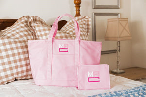 A pink tote bag and roadie are embroidered with a matching monogram.