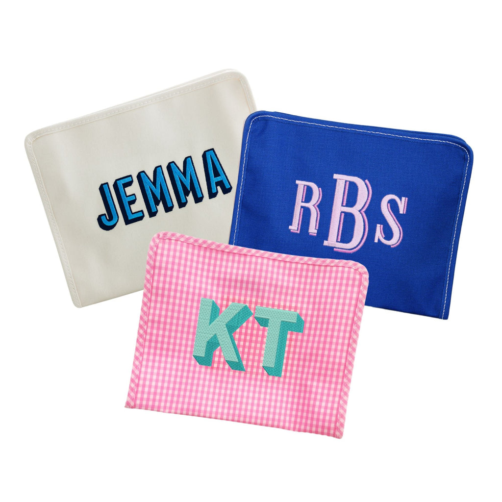 A solid cream, solid blue, and a pink gingham pouch are customized with embroidered names and monograms.